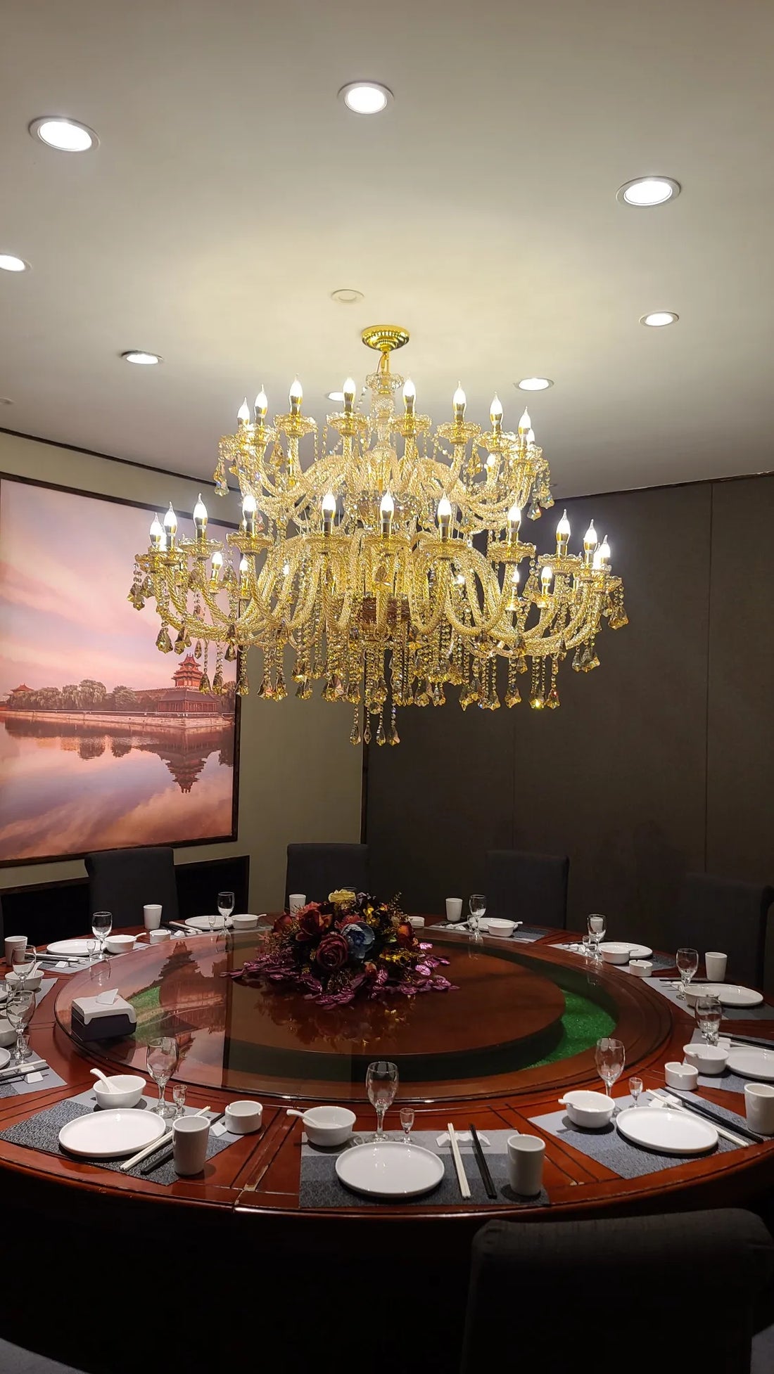Kerzen-Kronleuchter aus Cognac-Glas über einer festlichen Tafel