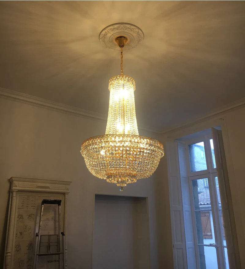 Empire-Kristall-Kronleuchter in Gold, eingeschaltet, in einem hohen Raum